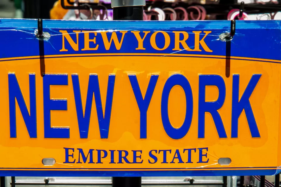 Yellow and blue novelty New York state license plate with NEW YORK plate.